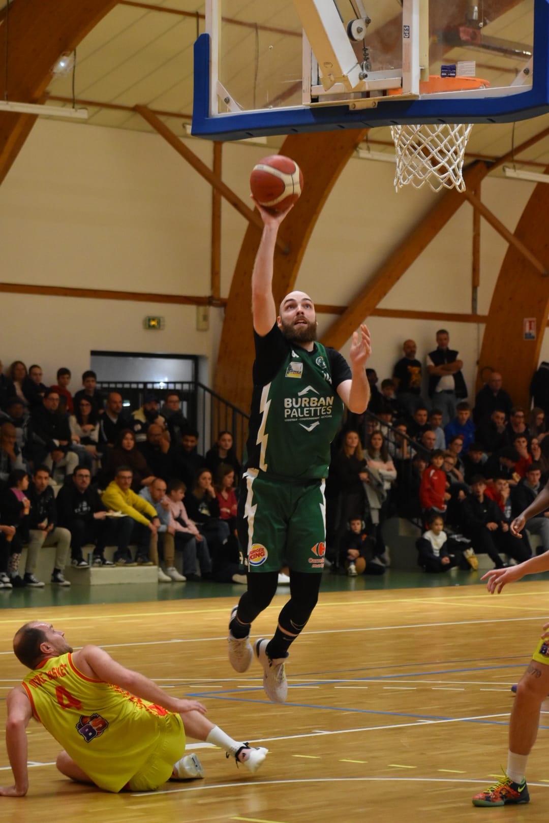 Entraineur de d'une équipe de Basket-ball et un joueur encourageant les joueurs sur le terrain.